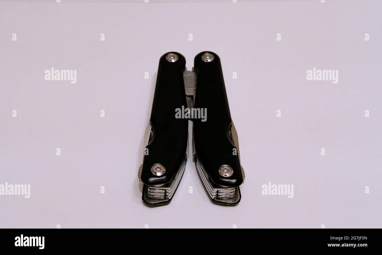 Black multitool folded on a white background Stock Photo