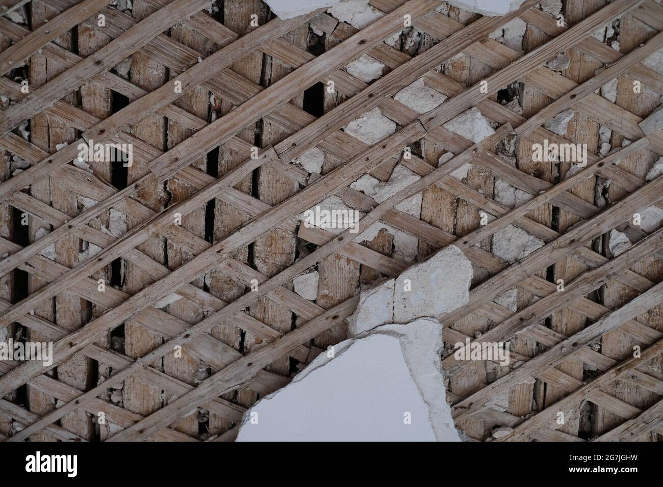 ruined wall with wooden crate and falling plaster Stock Photo