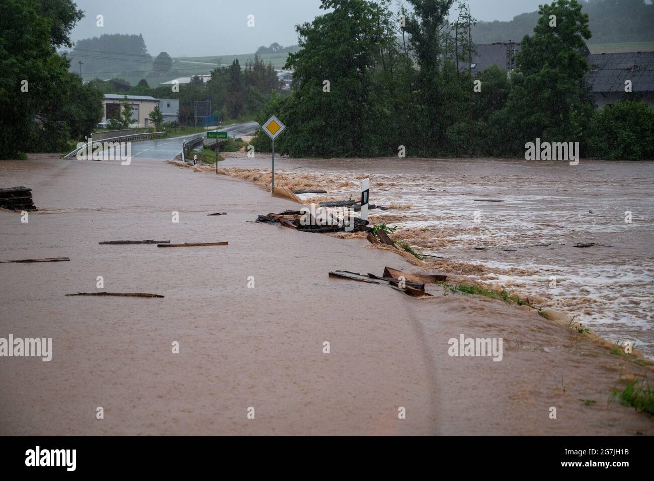 Seffern, Germany. 14th July, 2021. County road 74 between Rittersdorf and Nattenheim is flooded by the Nims. Continuous rainfall has flooded numerous villages and cellars in Rhineland-Palatinate. Credit: Harald Tittel/dpa/Alamy Live News Stock Photo