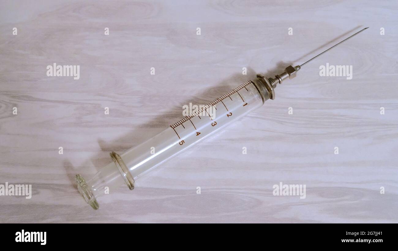 Glass syringe with a sharp metal needle Stock Photo