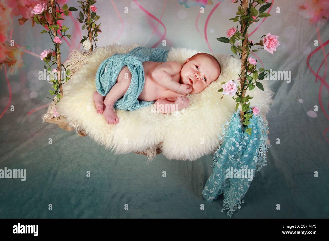 new born baby boy withUmbilical Cord Clamp still attached on red