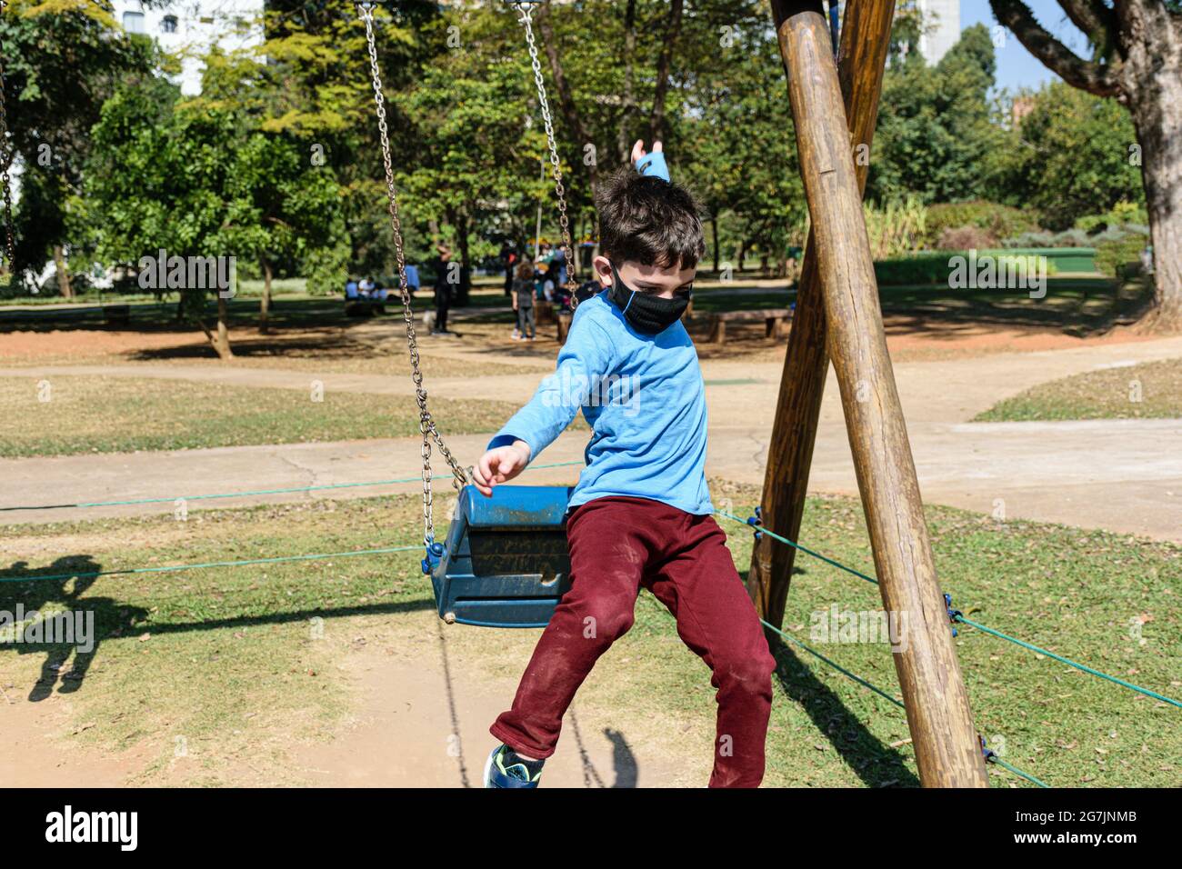 8 year old child jumping from a swing on a sunny day. Stock Photo