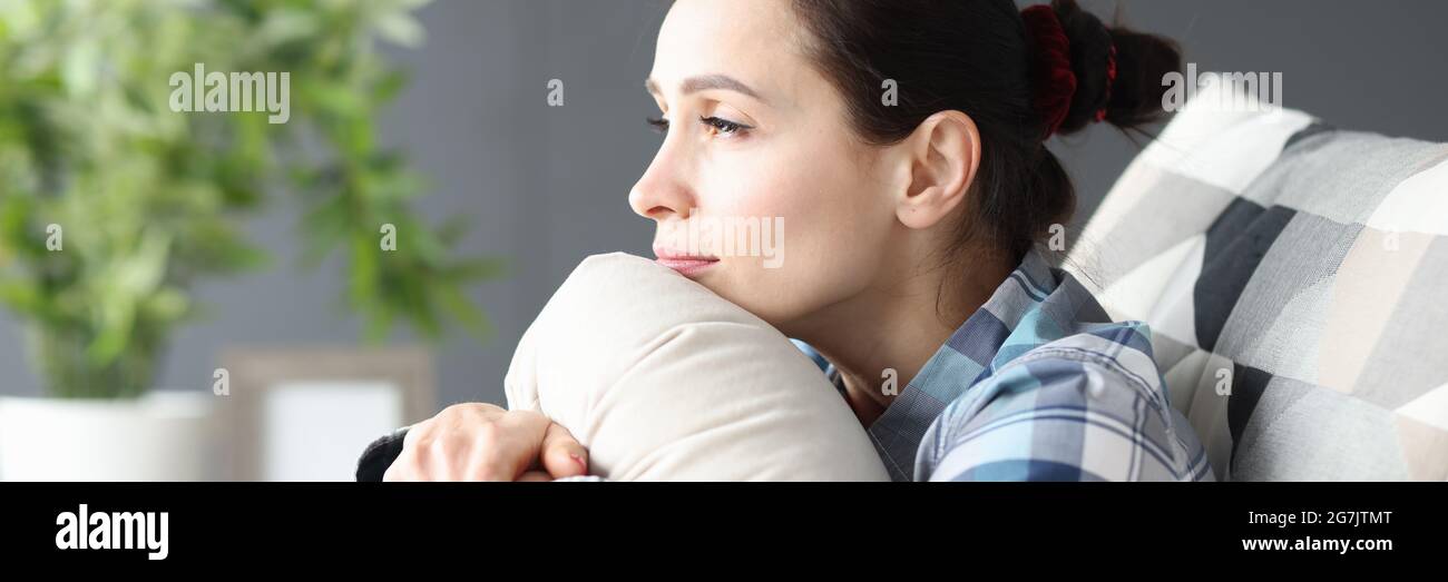 Portrait of young sad woman sitting on couch Stock Photo - Alamy