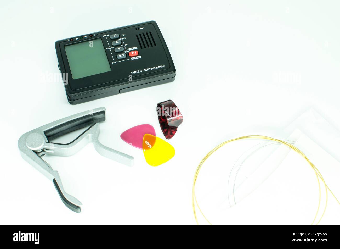 Music instrument accessories - Guitar tuner and strings isolated on ...