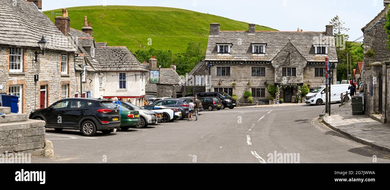 Corfe Castle, Dorset, England - June 2021: Cars parked in the village square in Corfe Castle. Stock Photo