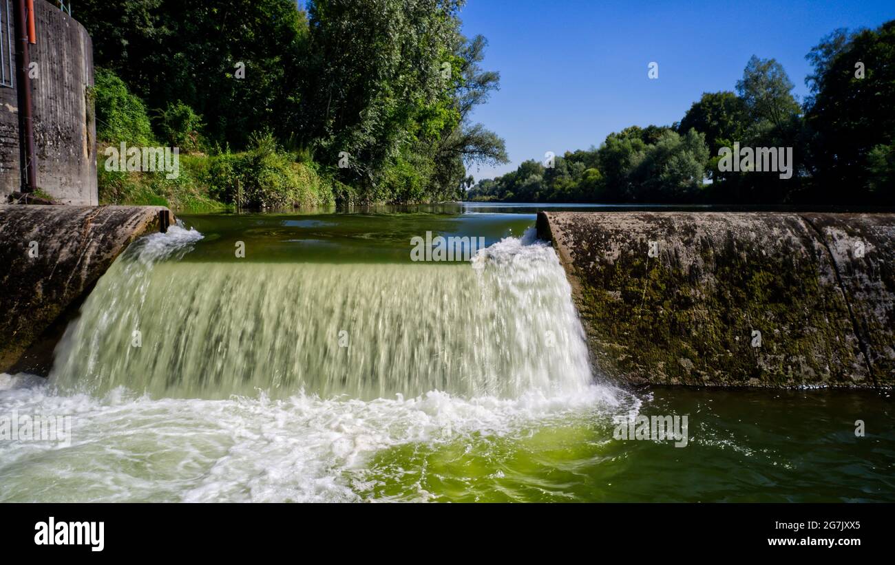 Small dam on a green flowing river Stock Photo - Alamy