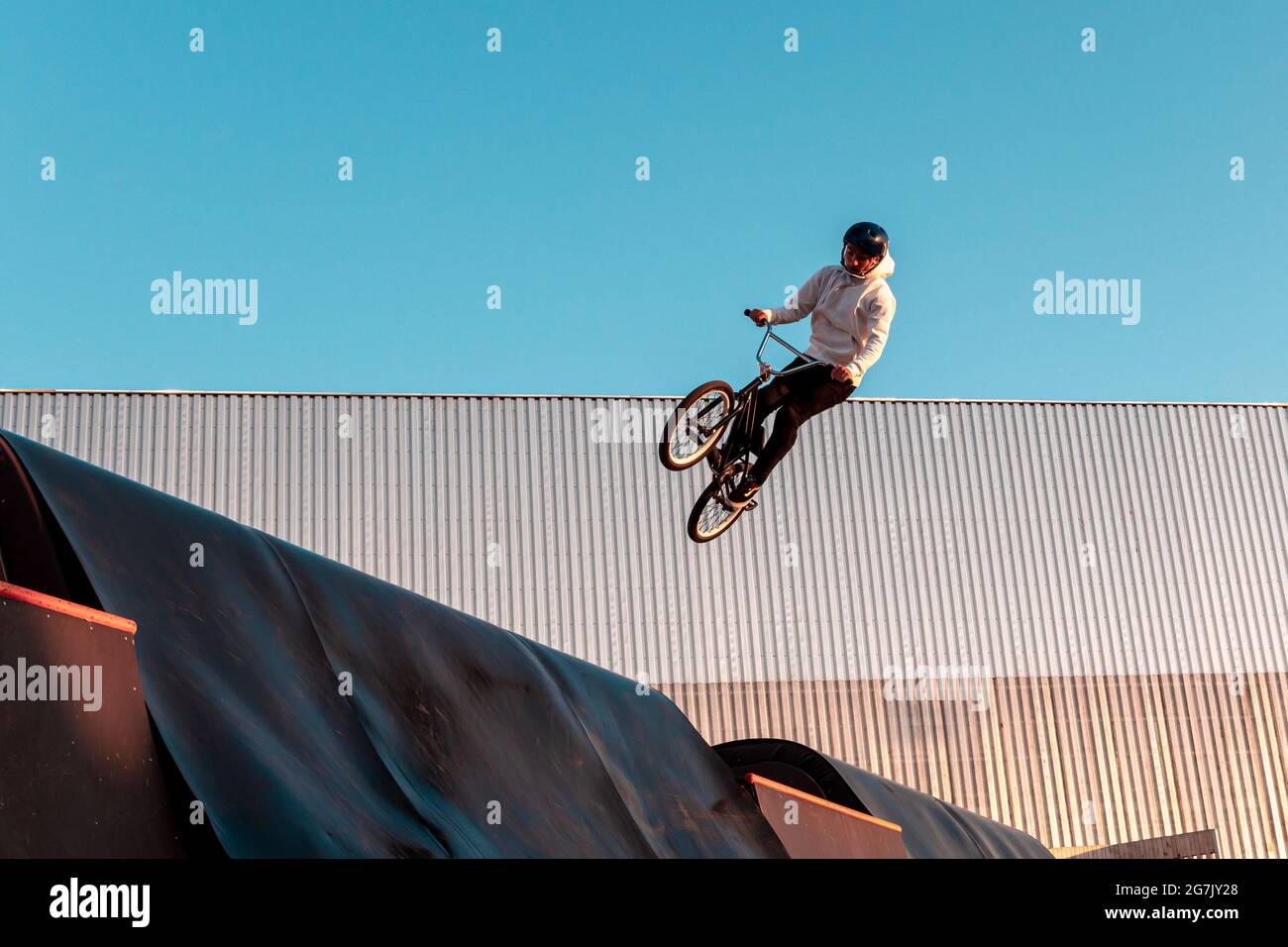 Kazan, Russia - September 12, 2020: A BMX rider does a stunt on a ramp in a skate park in the city public park for outdoor activities Stock Photo