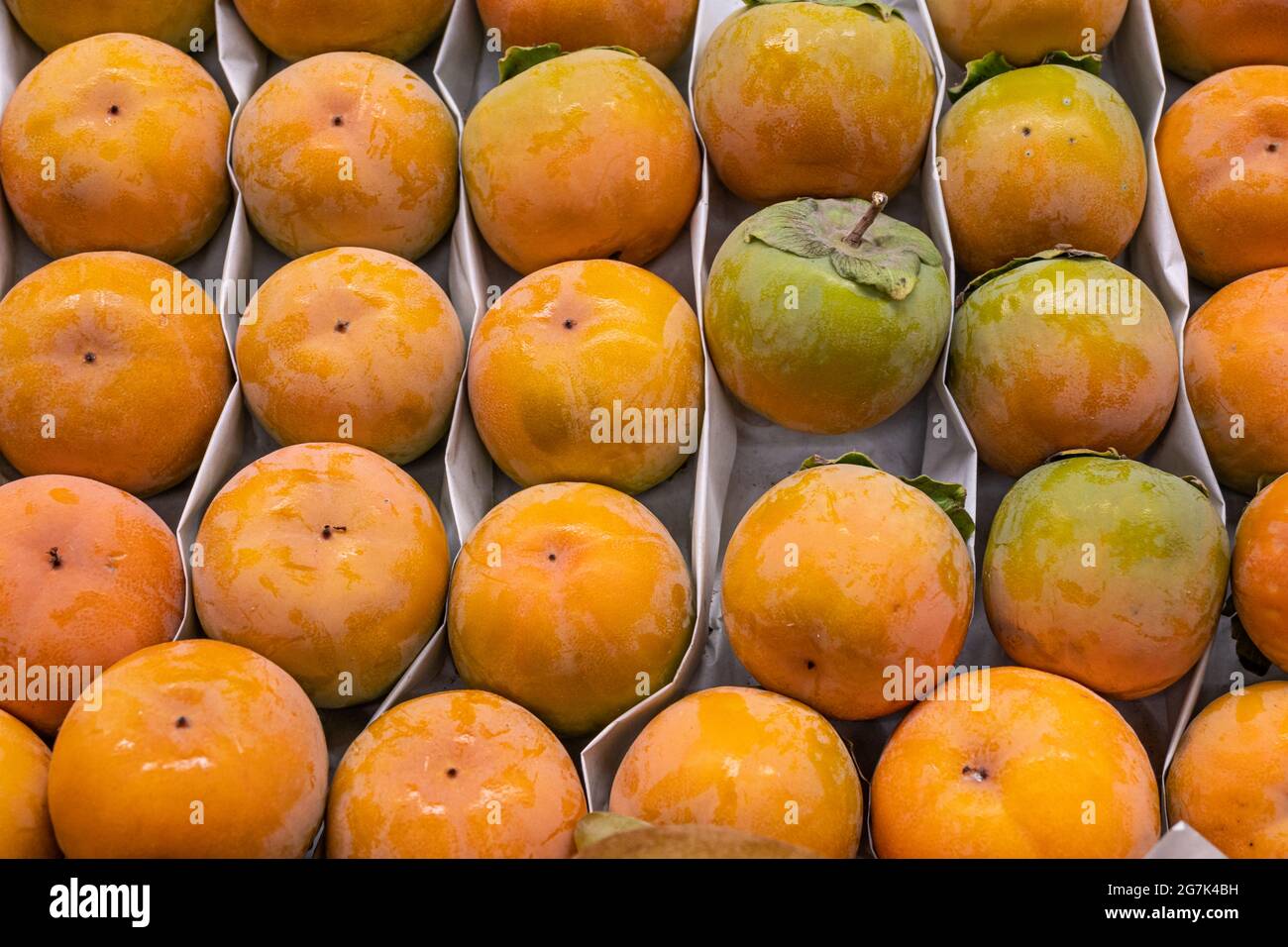 Fresh persimmon, a tray of ripe juicy persimmons close-up at the farmer's market Stock Photo