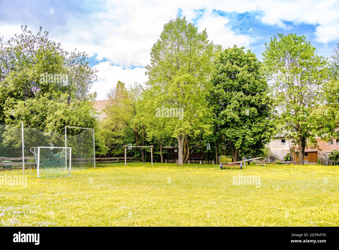 Small empty soccer field with goal on a springtime meadow in a village Stock Photo