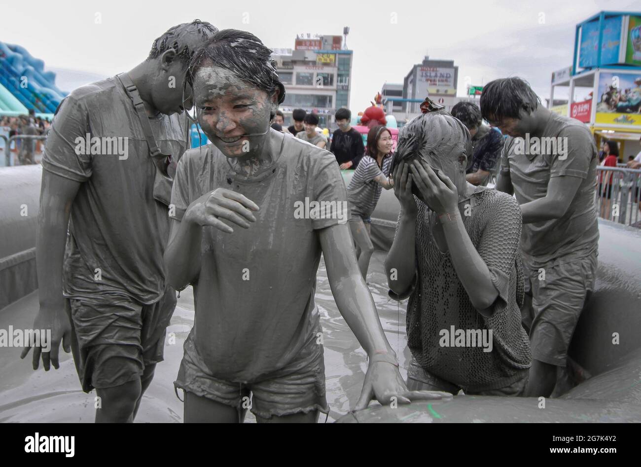 July 15, 2021-Boryeong, South Korea-A Visitors  enjoying wrestle in the mud pool during an Annual Boryeong Mud Festival at Daecheon Beach in Boryeong, South Korea. The mud, which is believed to have beneficial effects on the skin due to its mineral content, is sourced from mud flats near Boryeong and transported to the beach by truck. Stock Photo