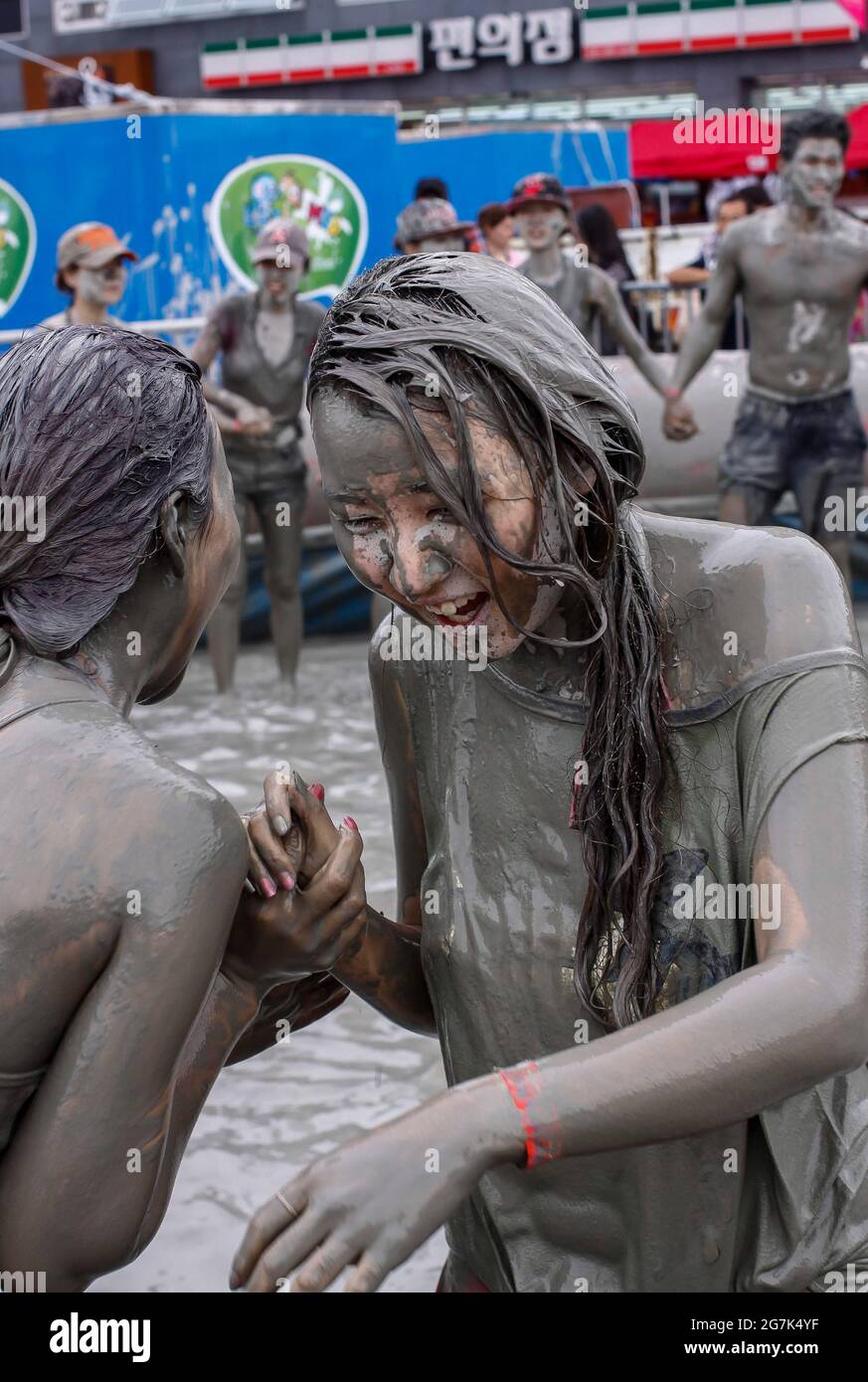 July 15, 2021-Boryeong, South Korea-A Visitors  enjoying wrestle in the mud pool during an Annual Boryeong Mud Festival at Daecheon Beach in Boryeong, South Korea. The mud, which is believed to have beneficial effects on the skin due to its mineral content, is sourced from mud flats near Boryeong and transported to the beach by truck. Stock Photo