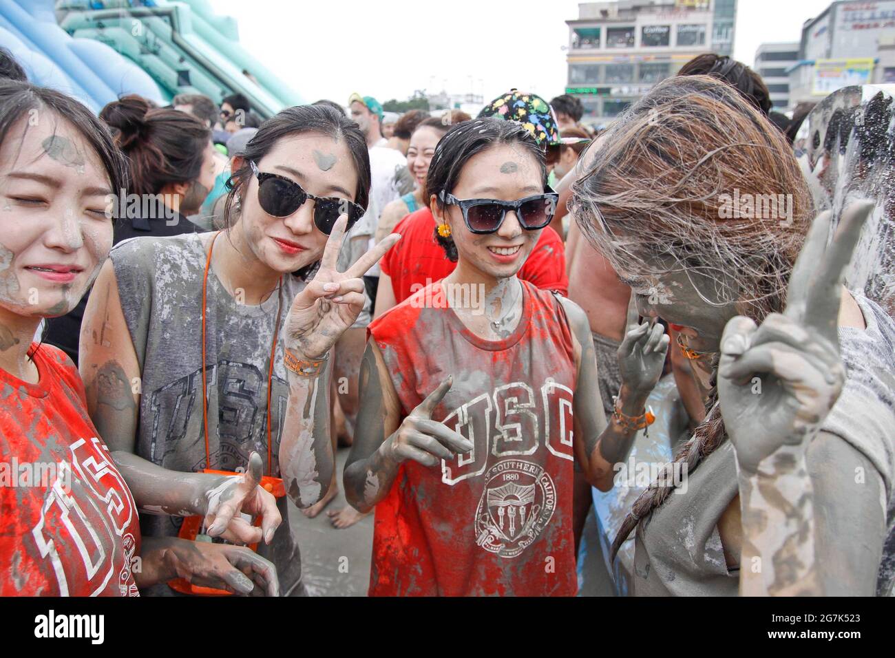 July 15, 2021-Boryeong, South Korea-A Visitors  enjoying wrestle in the mud pool during an Annual Boryeong Mud Festival at Daecheon Beach in Boryeong, South Korea. The mud, which is believed to have beneficial effects on the skin due to its mineral content, is sourced from mud flats near Boryeong and transported to the beach by truck. Stock Photo