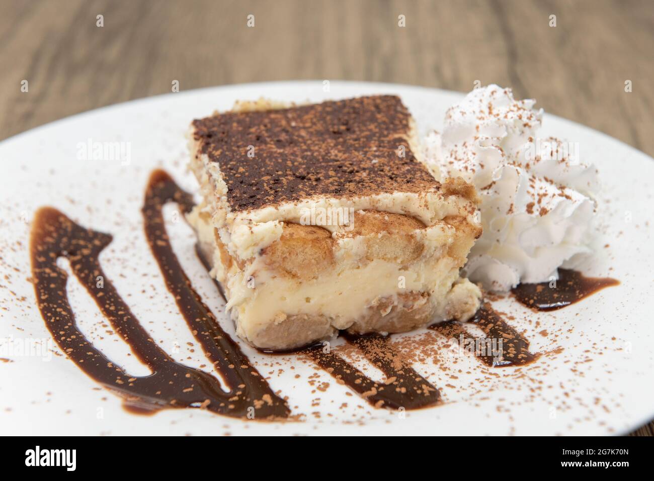Sweet dessert on a decorated plate of tiramisu cake to enjoy after a meal. Stock Photo