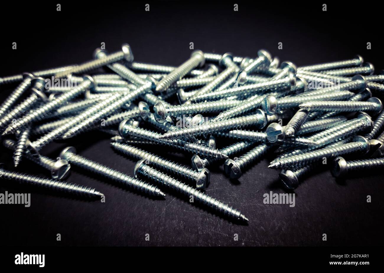Close up of a new stack of iron nails on a black isolated background