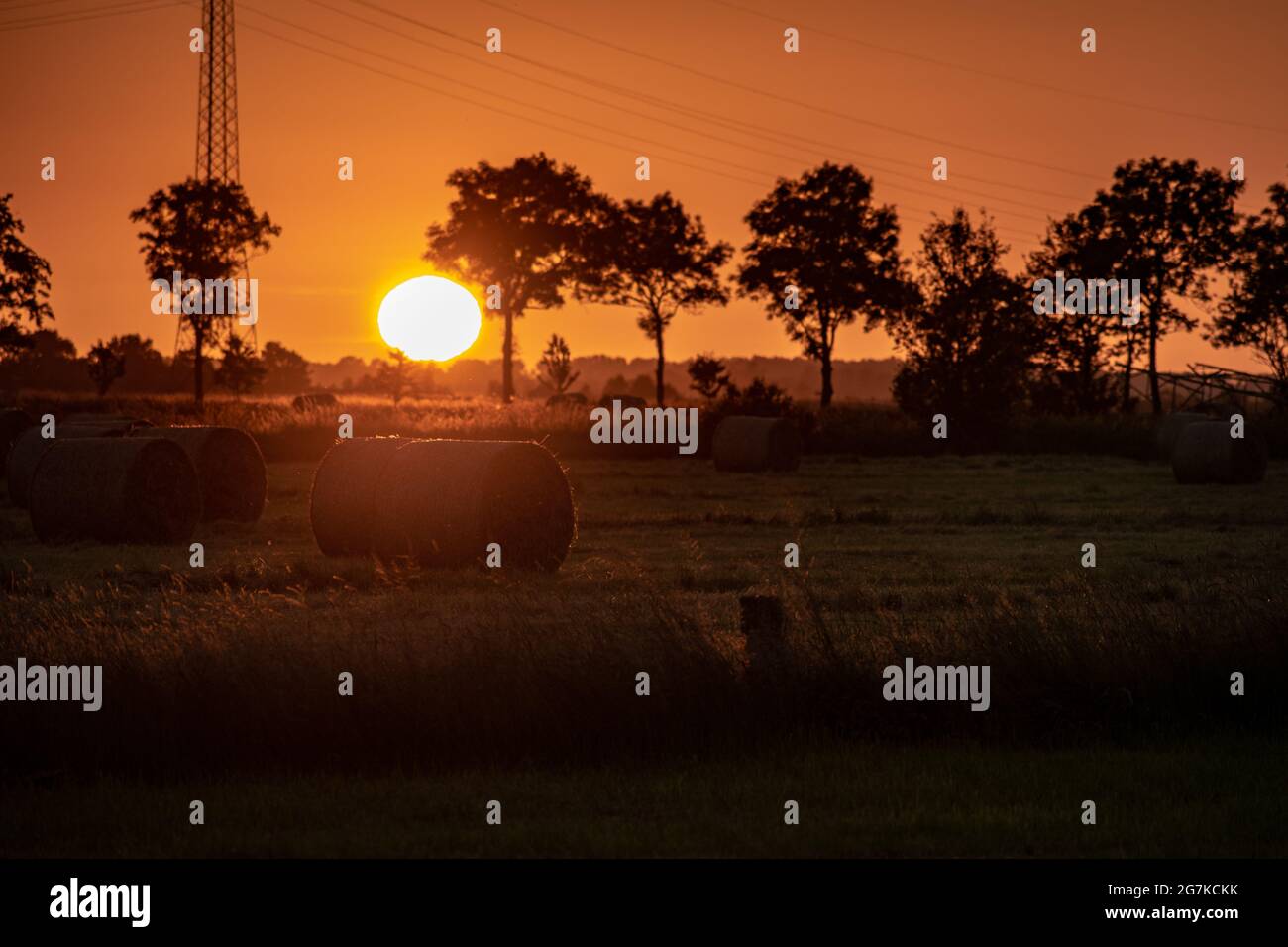 Hay bales in a field during sunset Stock Photo - Alamy