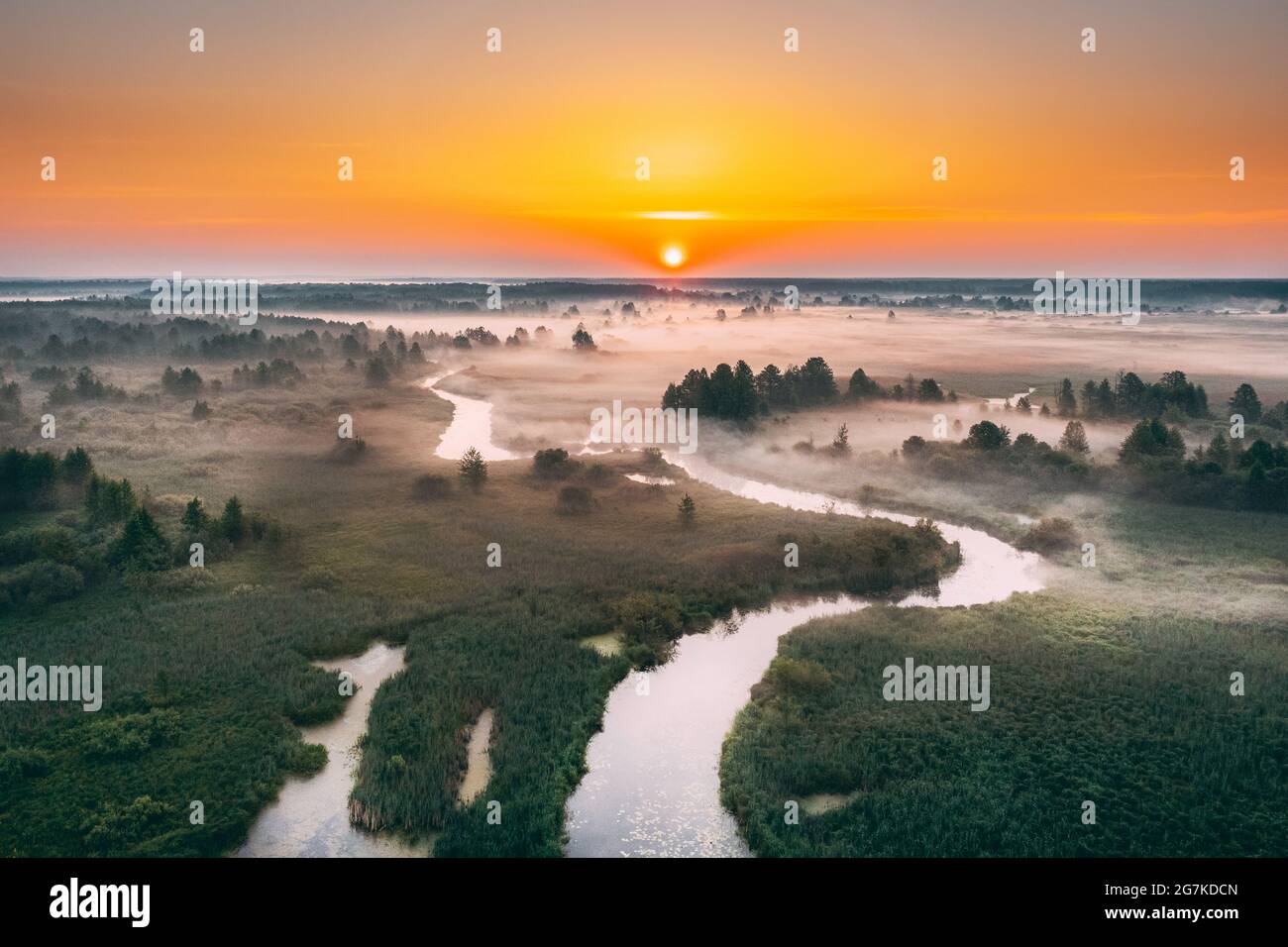 Aerial View Green Meadow And River Landscape In Misty Foggy Morning. Top View Of Beautiful European Nature From High Attitude In Summer Season. Drone Stock Photo
