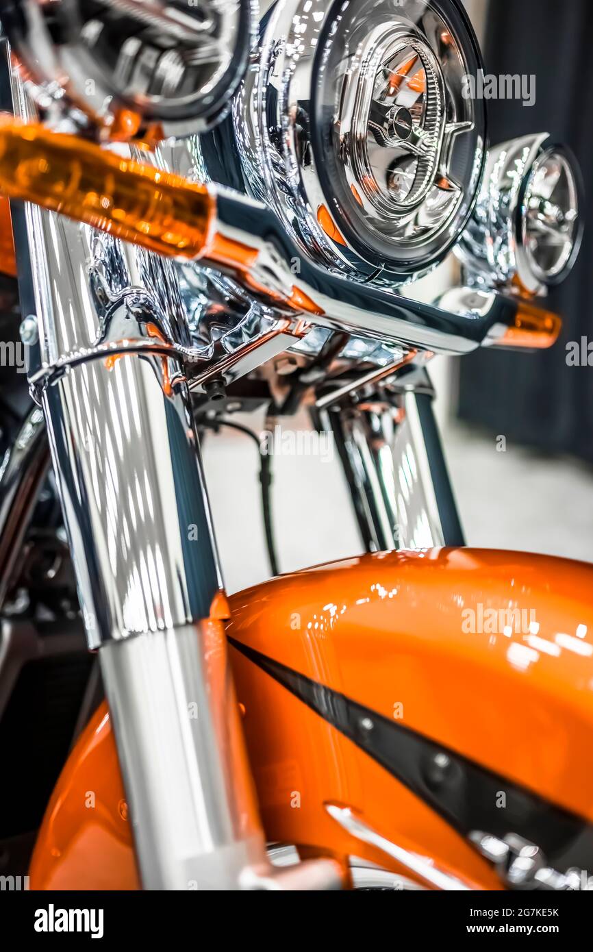 Shine orange motorcycle with a powerful fork and stylized headlamp stands on the court in the light reflection demonstrating their capabilities for ri Stock Photo