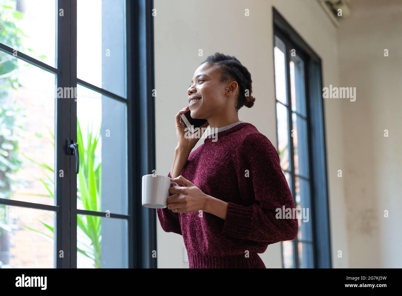 African black female businessman holding a water glass standing by the