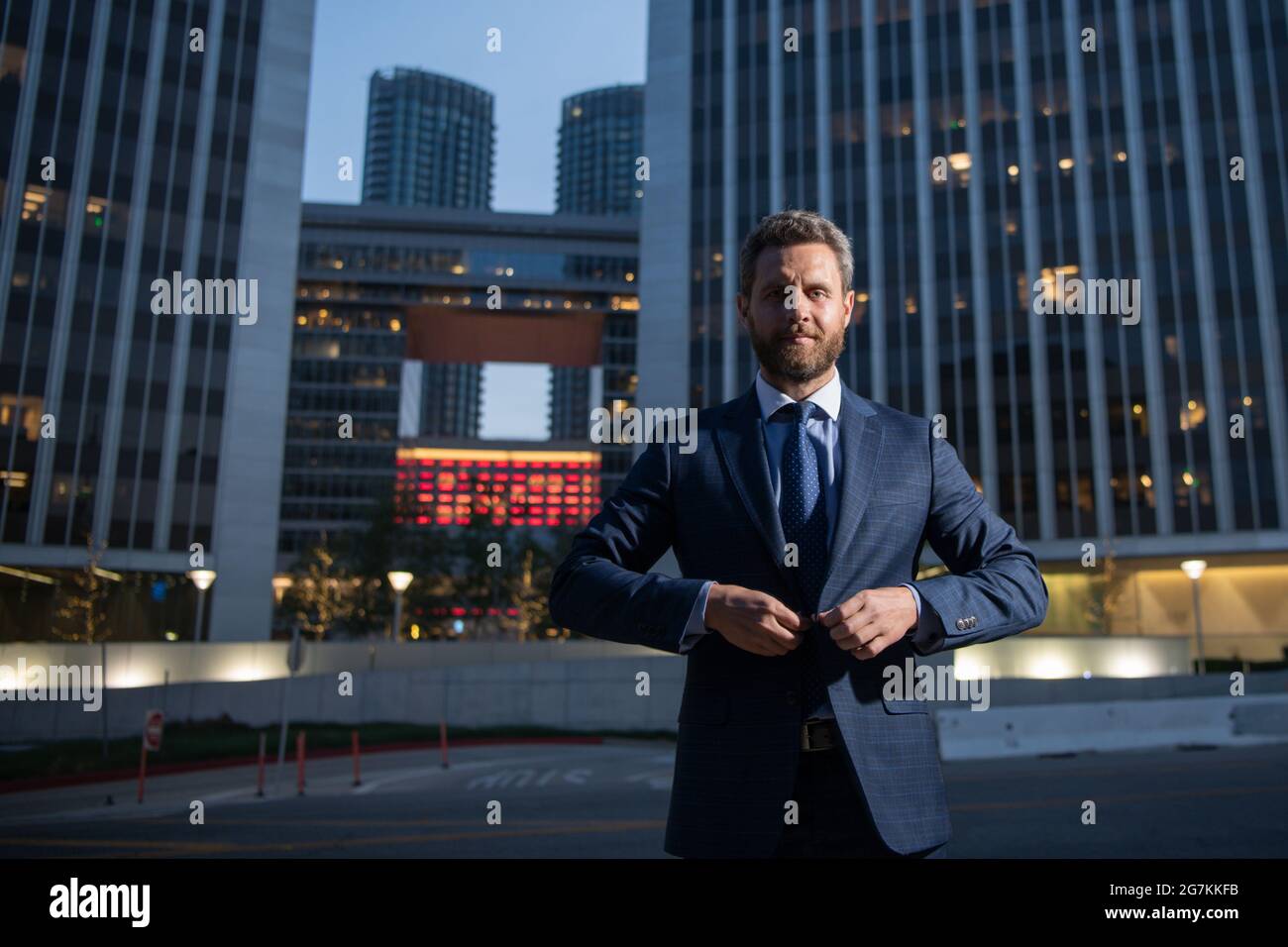 Executive businessman. Portrait of ceo near modern office in suit. Happy leader standing in front of company building. Stock Photo