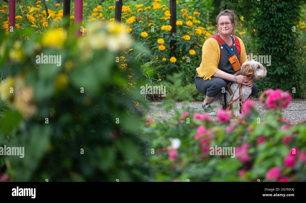 Hameln, Germany. 14th July, 2021. Katja Gleisberg squats with her dog Frida in Bürgerpark. The 42-year-old from Hamelin experienced sexualised violence in her childhood and reported her stepfather in 2013 - 20 years after the experience. Victims like Katja Gleisberg demand protection concepts for children. (to dpa "Tatort Familie: Betroffene fordern Schutzkonzepte für Kinder") Credit: Julian Stratenschulte/dpa/Alamy Live News Stock Photo