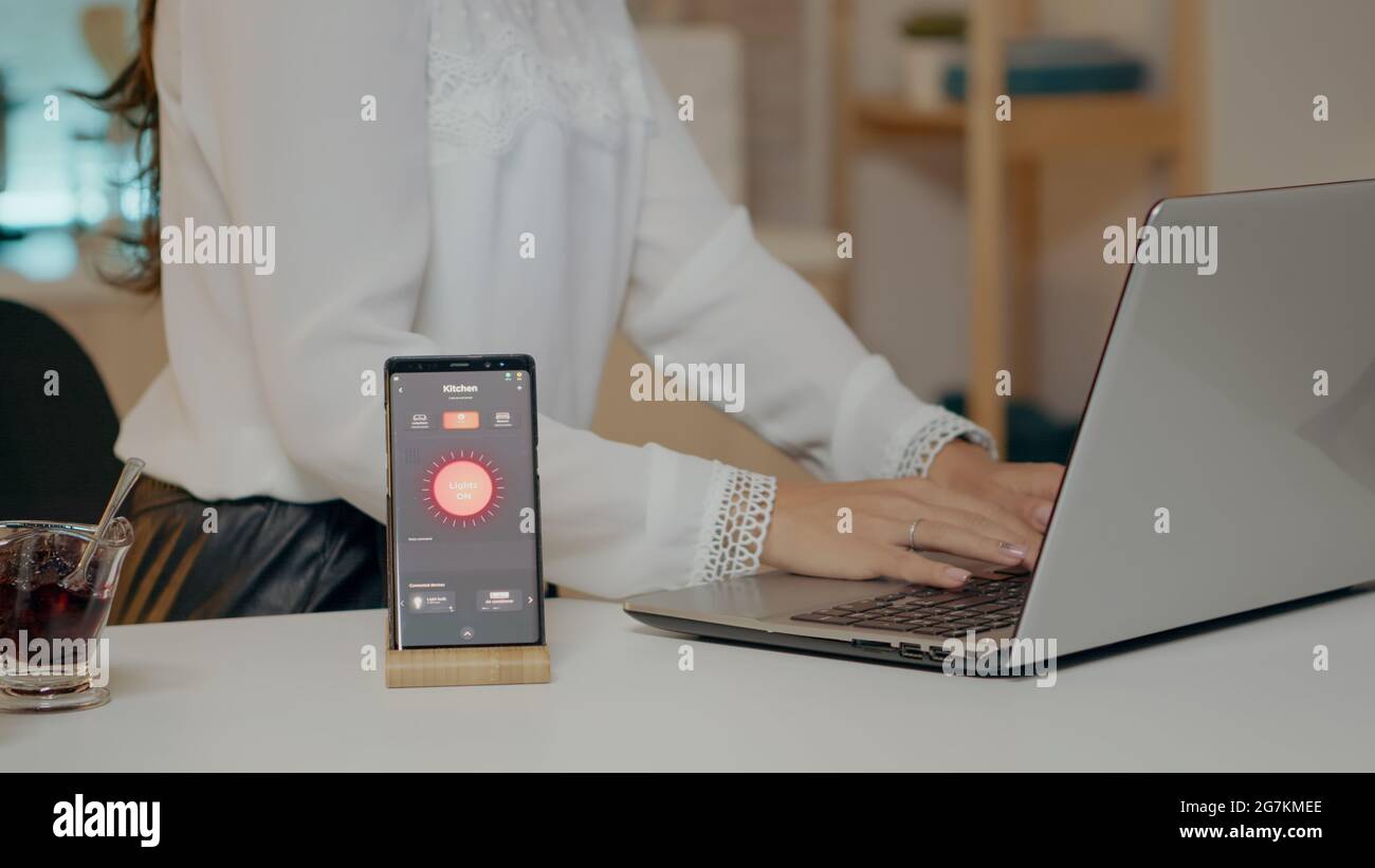 Woman using smart home app with voice assistant controlling light ...