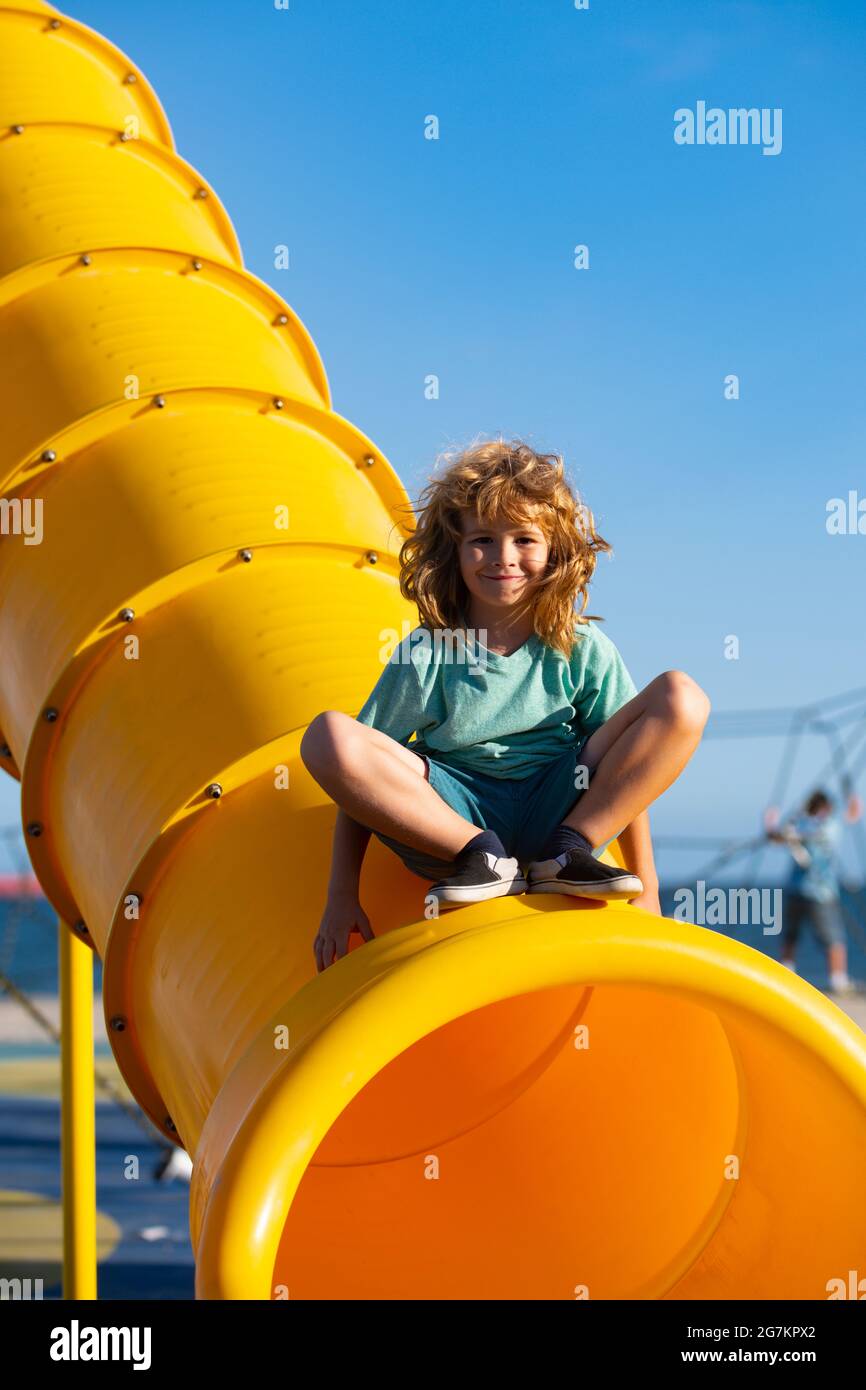 Child on slide playground area. Cute boy in the kids park having fun