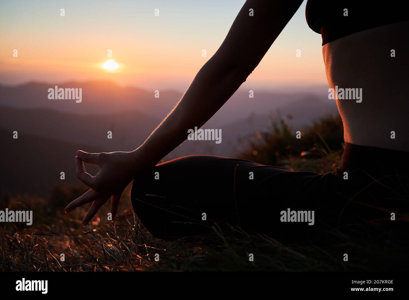 Close-up view of woman's body in Lotus pose. Female is meditating in ...
