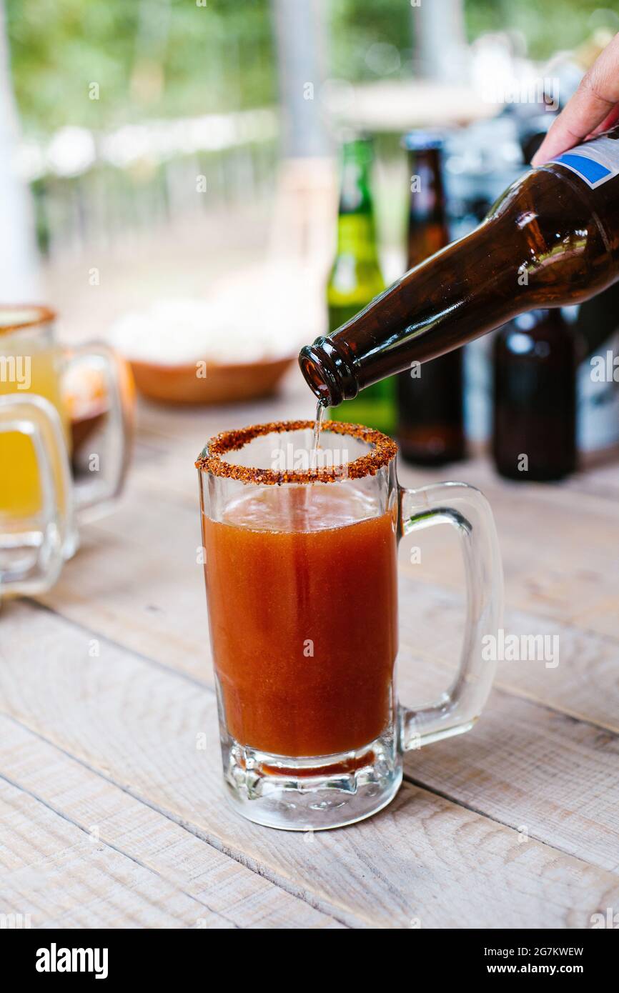 Michelada mexican beer with tomato juice, hot sauce and lemon, Mexican  cocktail drink in Mexico Stock Photo - Alamy