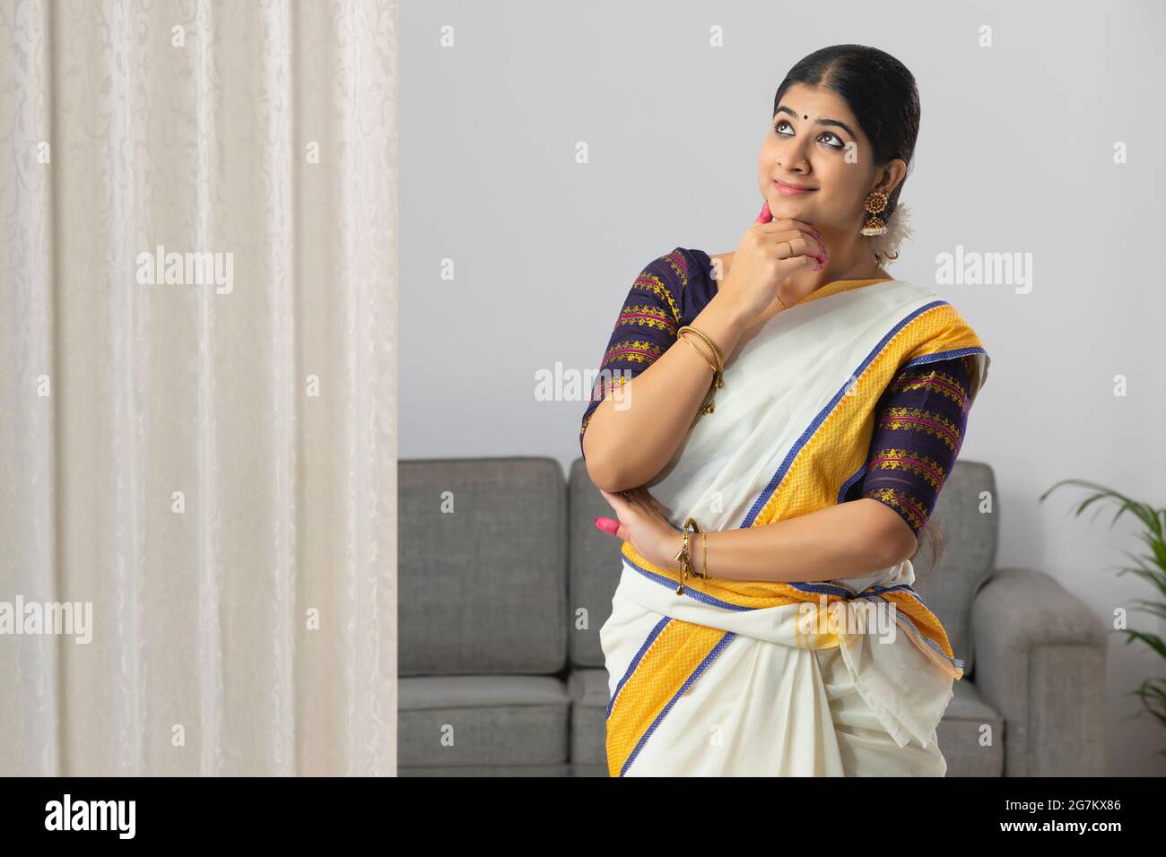 Woman in a South Indian saree practicing Mushti mudra with an expression of amazement on her face Stock Photo