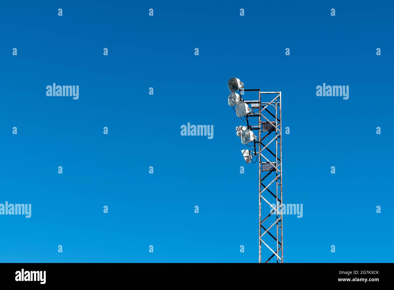 Low angle view of floodlights on a tower against blue sky Stock Photo