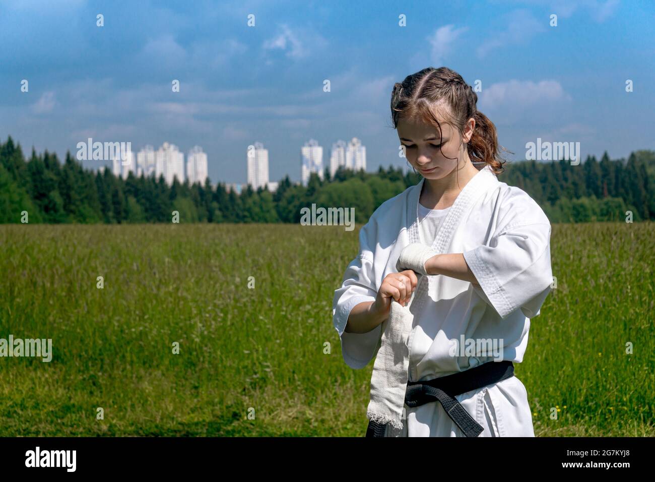 teenage girl in a kimono wrapping a wrist wrap around her hand before