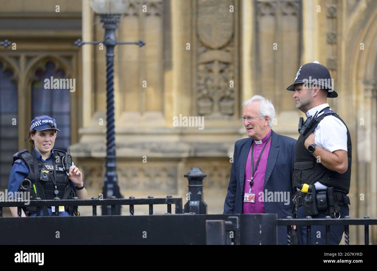 The Right Reverend David Urquhart, Bishop of Birmingham, talking to police officers outside the Houses of Parliament, Westminster, London Stock Photo
