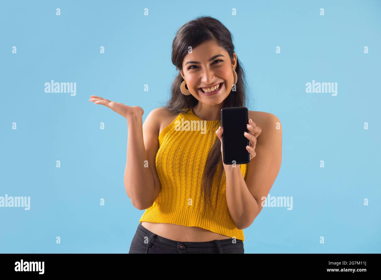 A young woman showing her mobile phone. Stock Photo