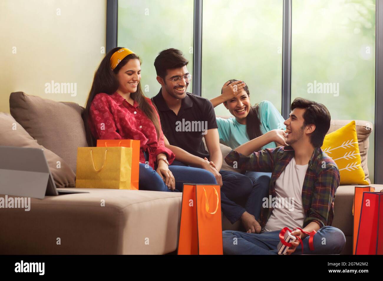 A Group of youngsters talking happily in a room after a shopping spree. Stock Photo