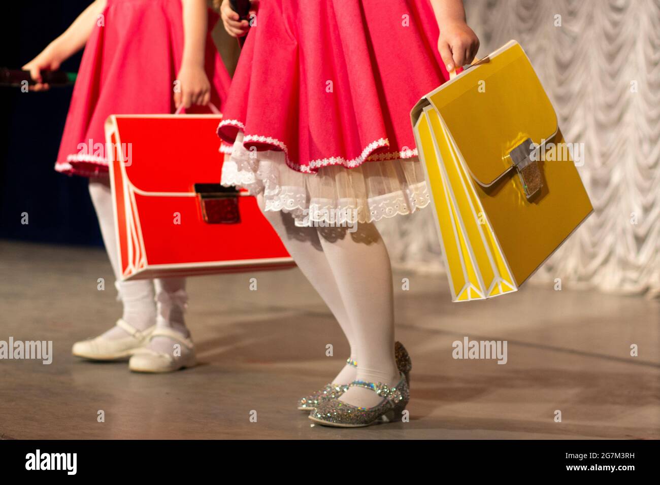 Girls with school bags. Schoolgirls in dresses. Bright clothing accessories for children. Stock Photo