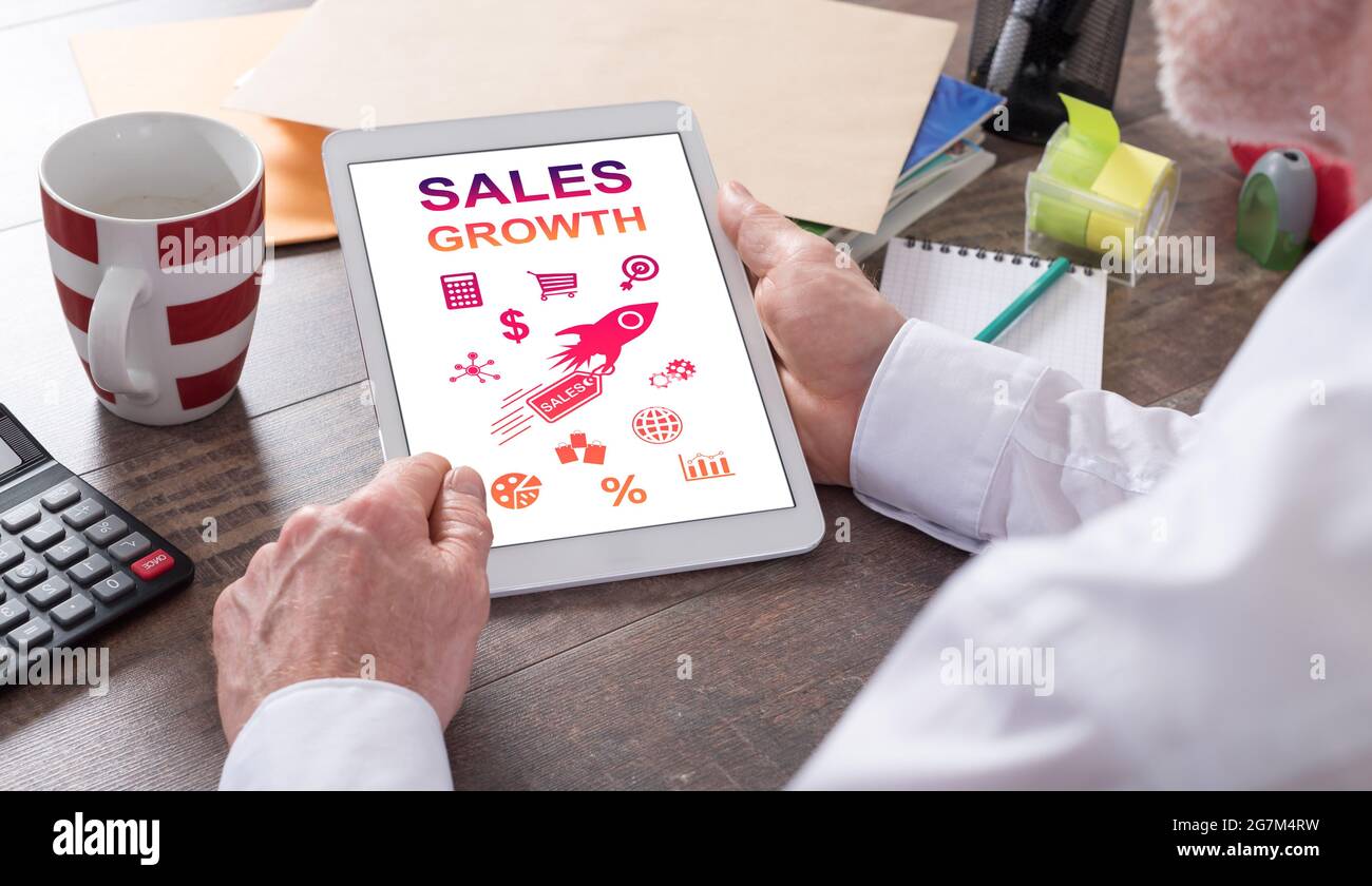 Sales growth concept shown on a tablet held by a man Stock Photo