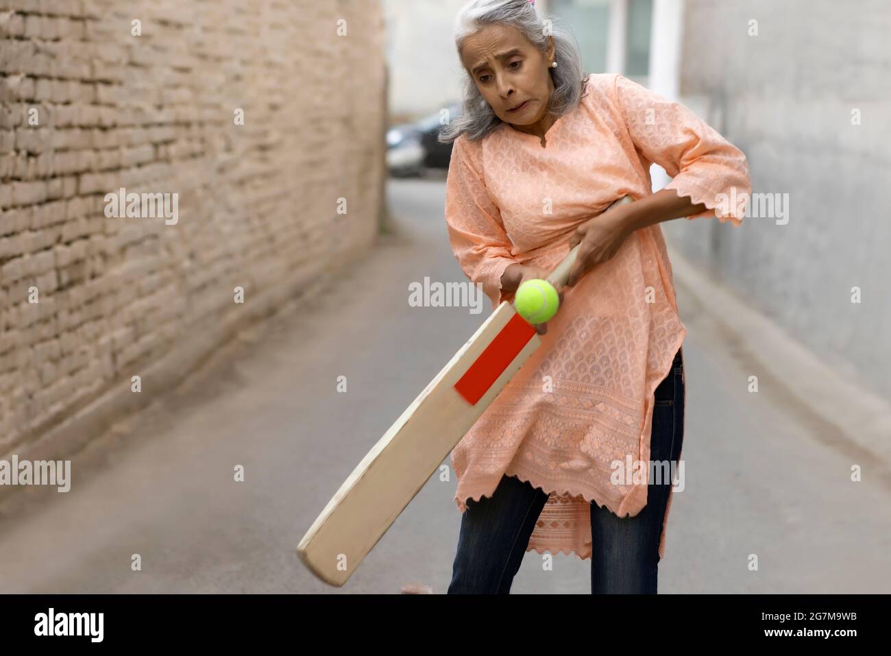 An old woman playing cricket. Stock Photo