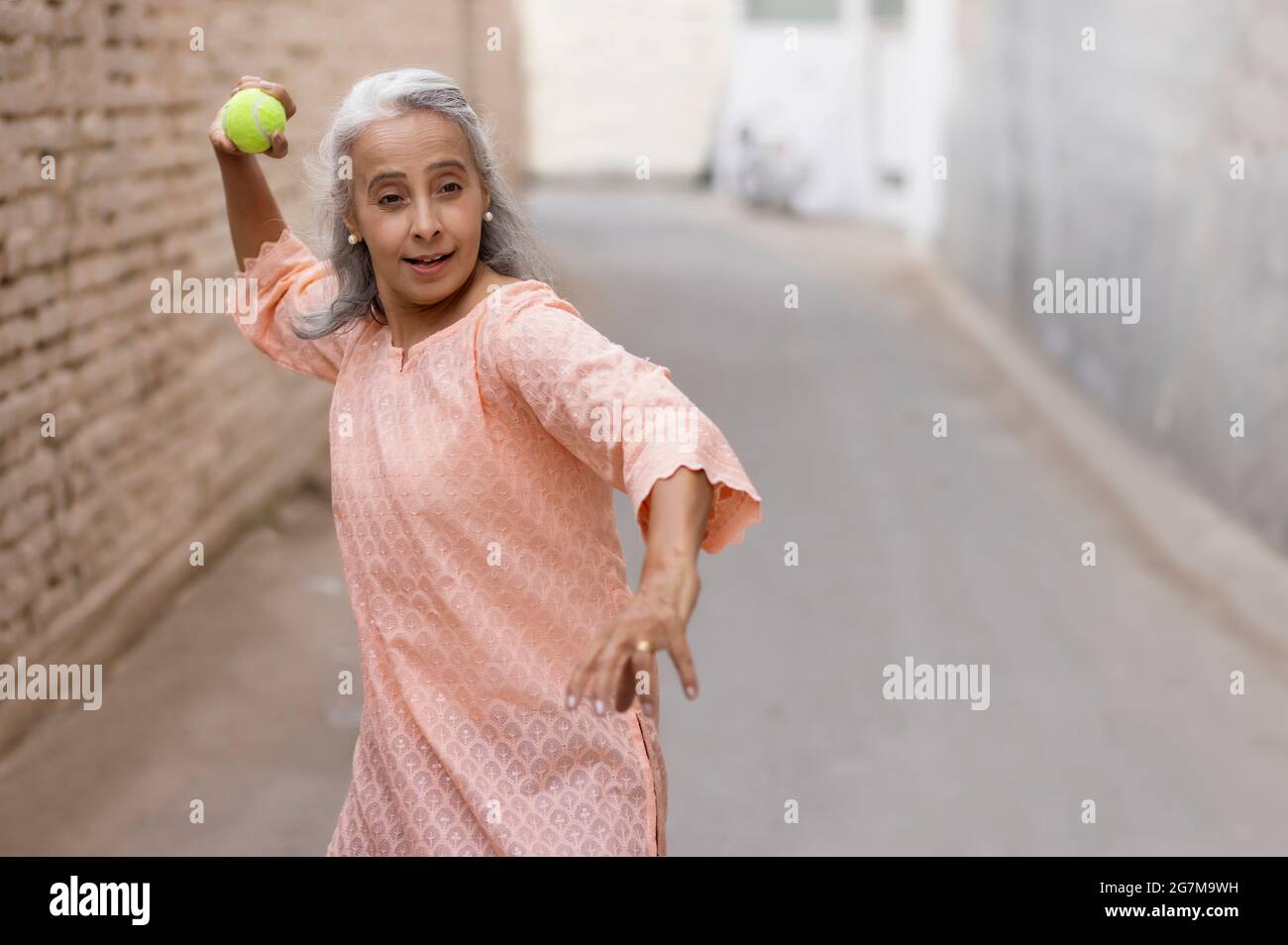 An old woman playing cricket Bowling. Stock Photo