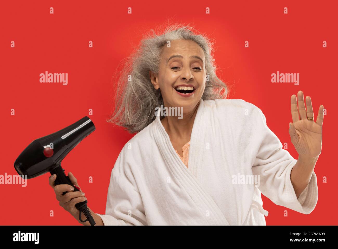 Senior woman blow drying hair hires stock photography and images Alamy
