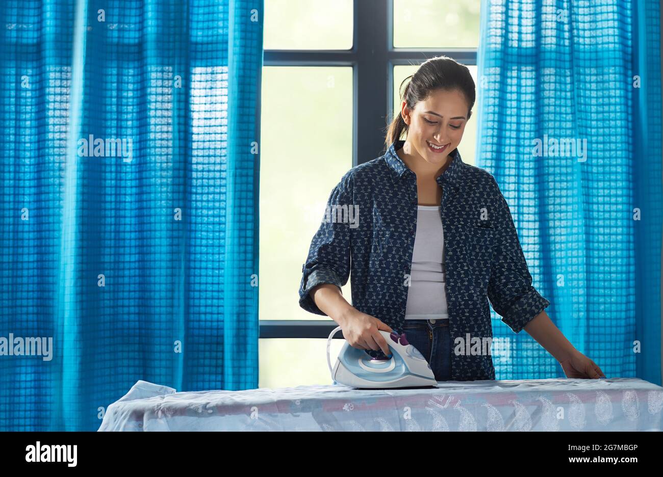 A woman ironing her clothes in her room Stock Photo Alamy