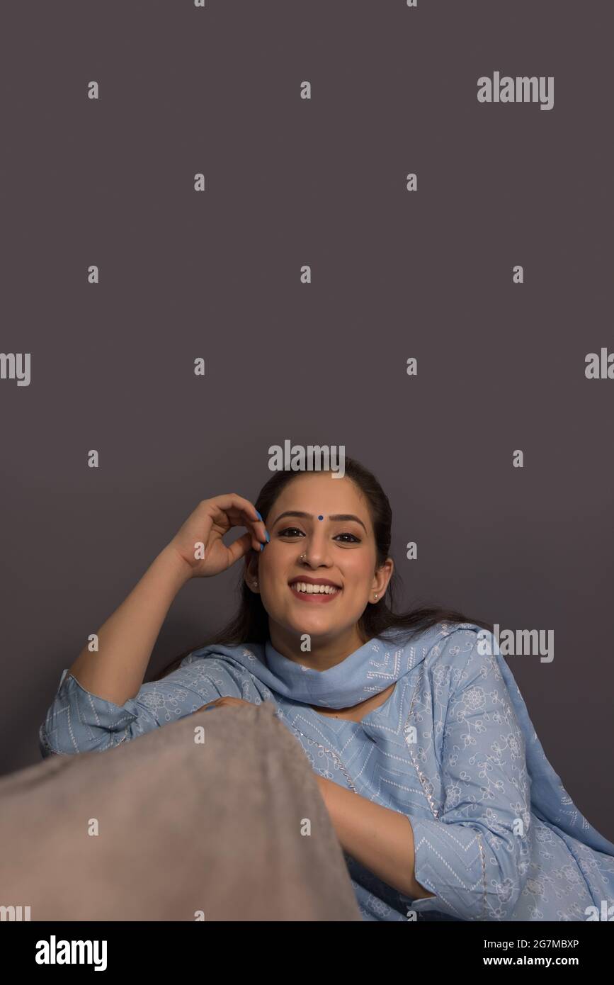A cheerful woman sitting in her room. Stock Photo