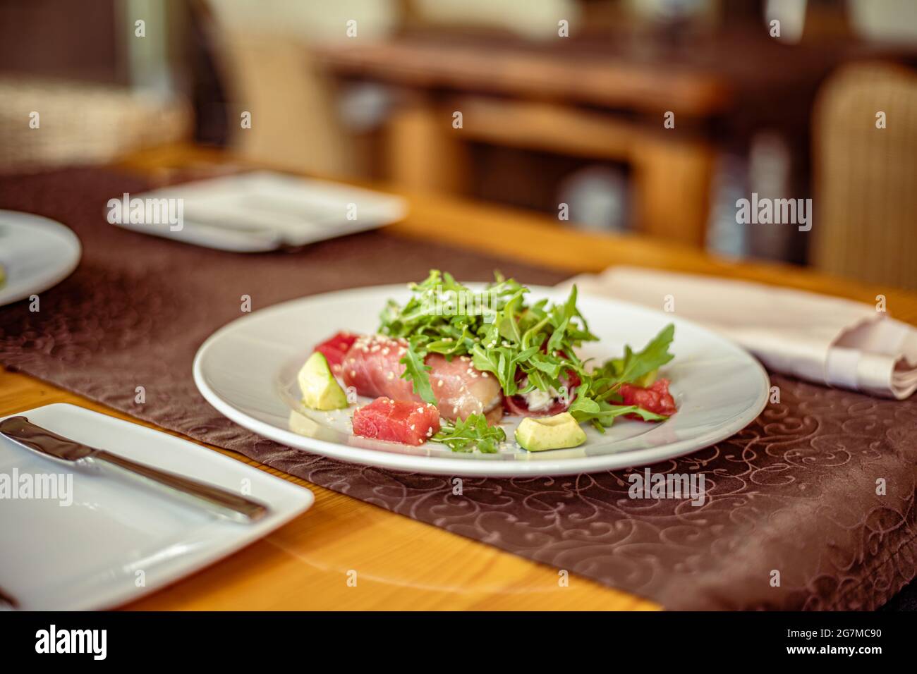 Salad of red fish Salmon, roll with Kamchatsky king crab, arugula, avocado, sesame and oil Stock Photo