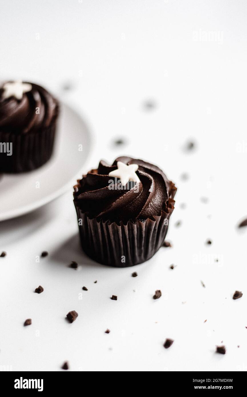 Vertical shot of chocolate cupcake with star topping on white background Stock Photo