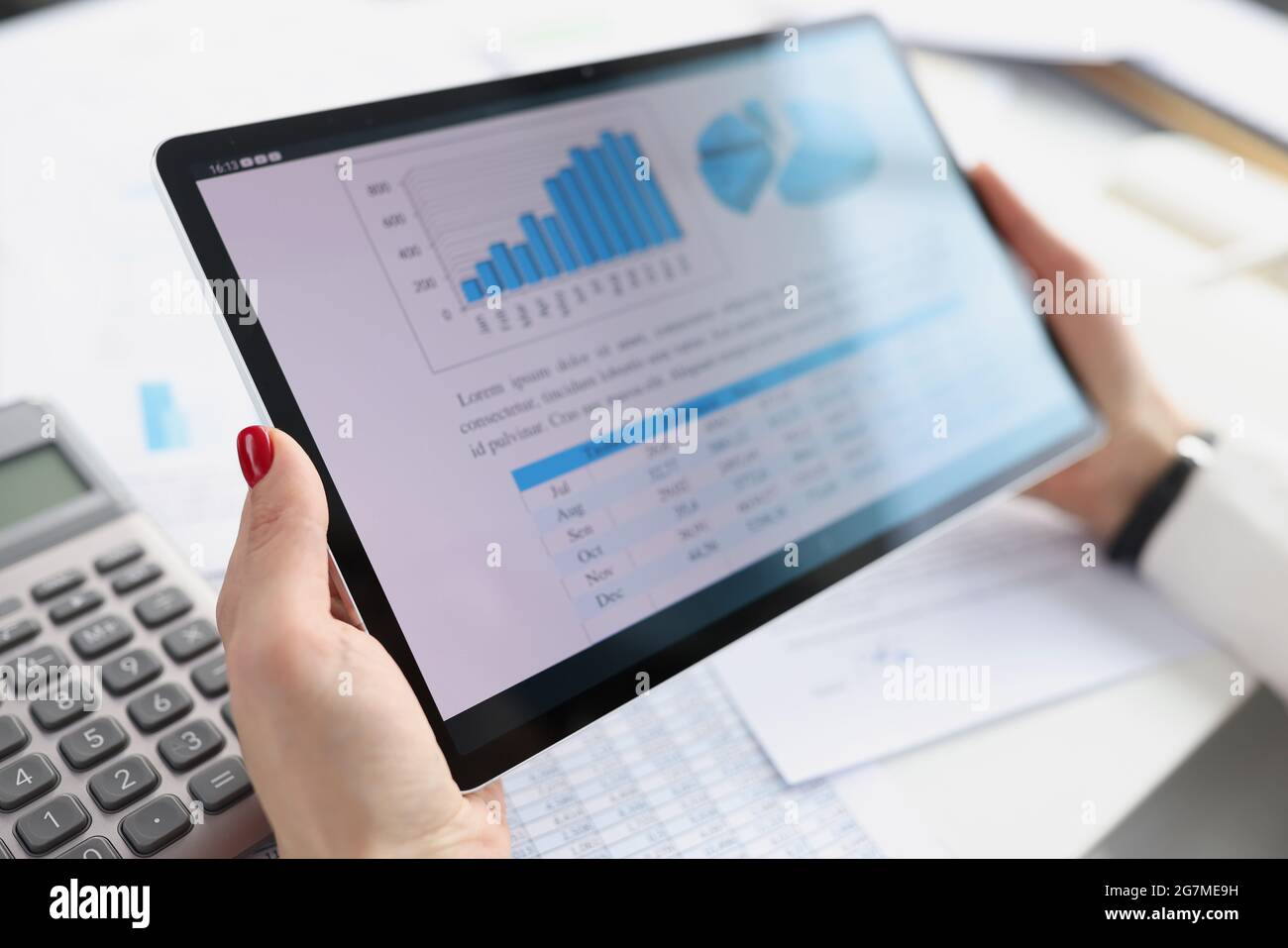 Woman holding digital tablet with charts in her hands closeup Stock Photo