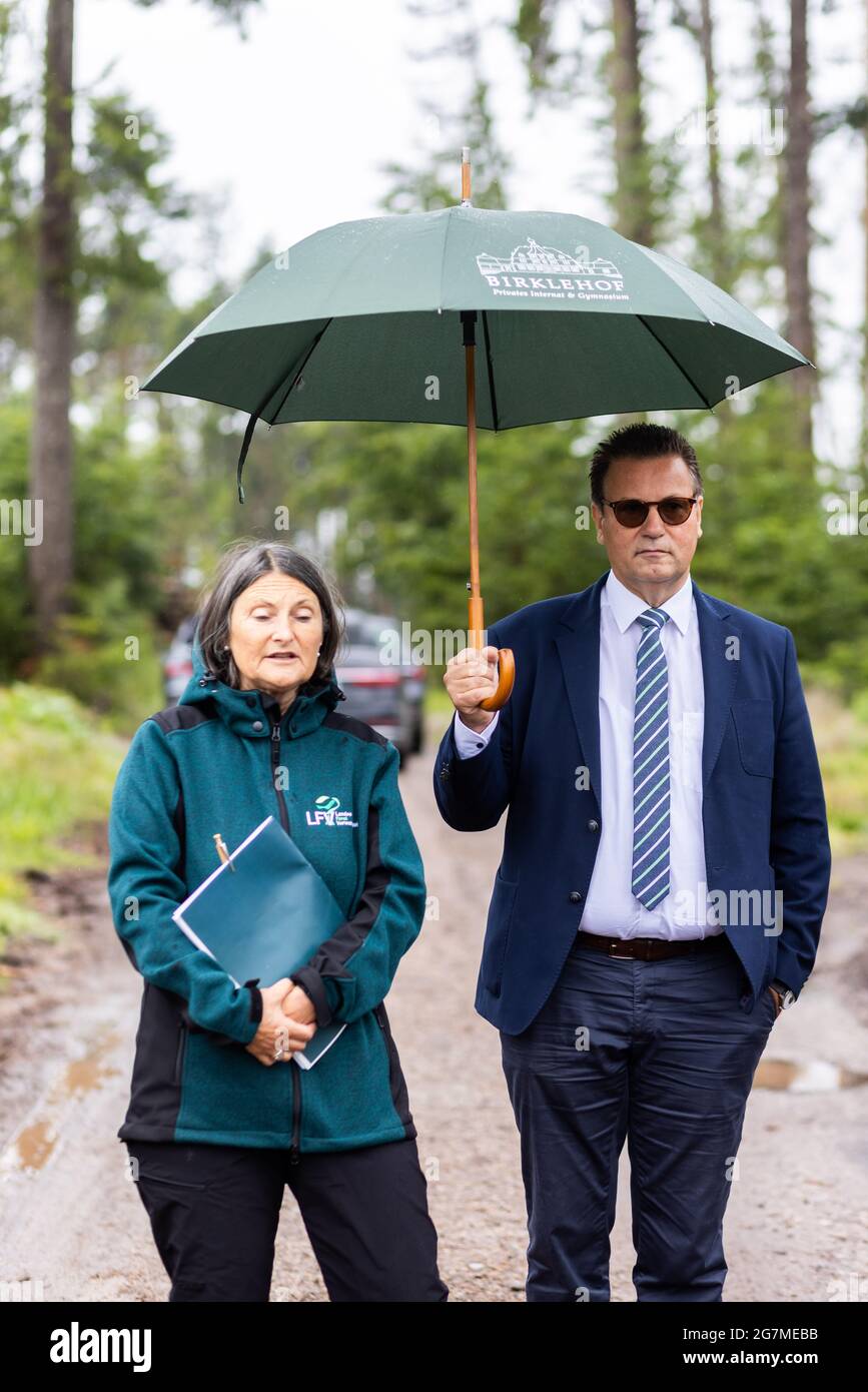 Albbruck, Germany. 15th July, 2021. Freiburg District President Bärbel Schäfer and State Minister Peter Hauk (CDU, with umbrella) stand during an inspection in the forest. The southern Black Forest is one of the regions in Baden-Württemberg most affected by extreme weather-related forest damage. In order to develop solutions, the forest was declared a model area. The aim of the project is to support and quickly help forest owners both in dealing with the damage and in reforesting the damaged areas. Credit: Philipp von Ditfurth/dpa/Alamy Live News Stock Photo