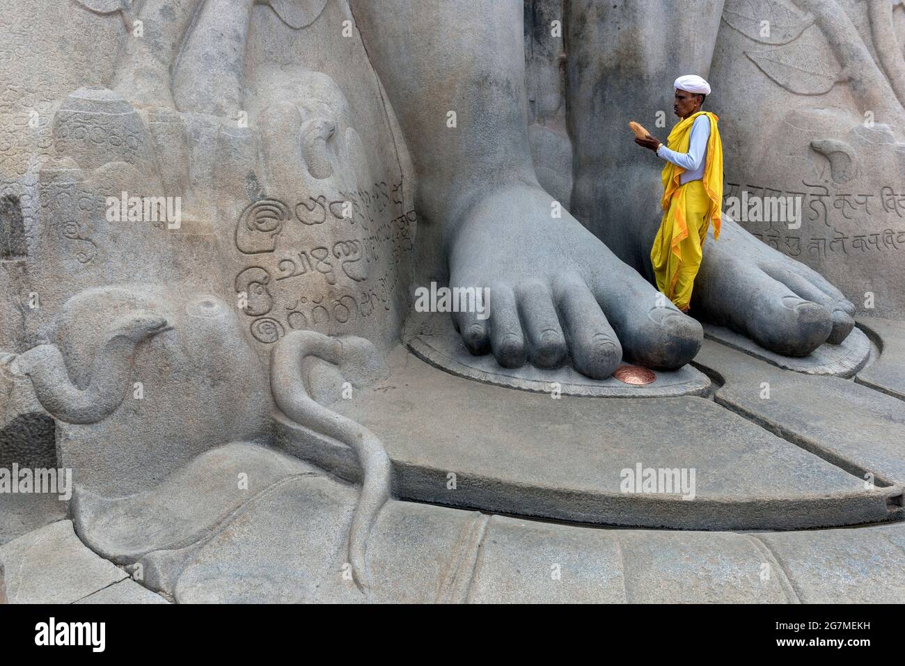 A Jain pilgrim makes a prayer at the  Bahubali Gommateshwara Statue, Shravanabelagola Stock Photo