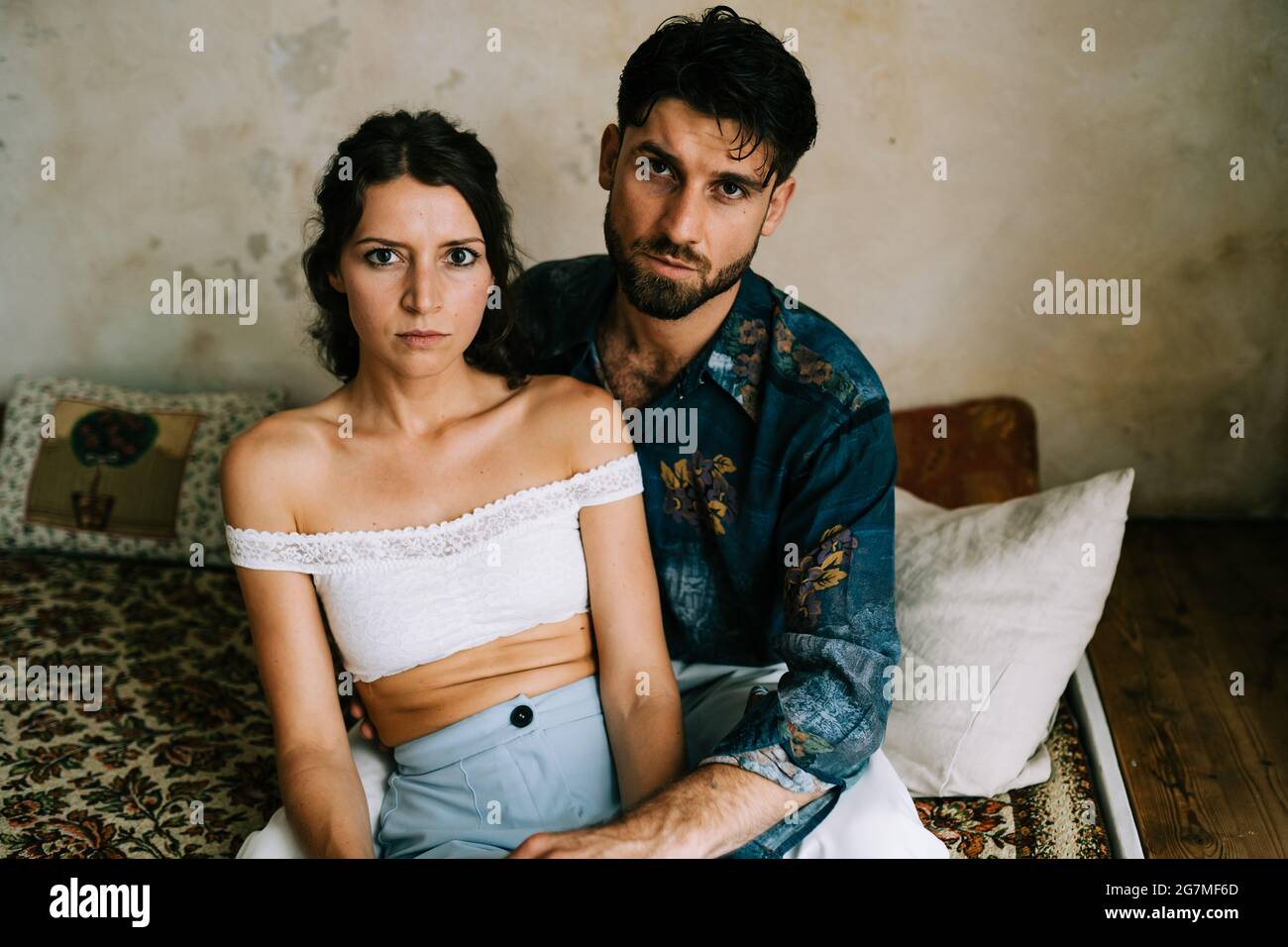 serious heterosexual couple sitting on sofa Stock Photo