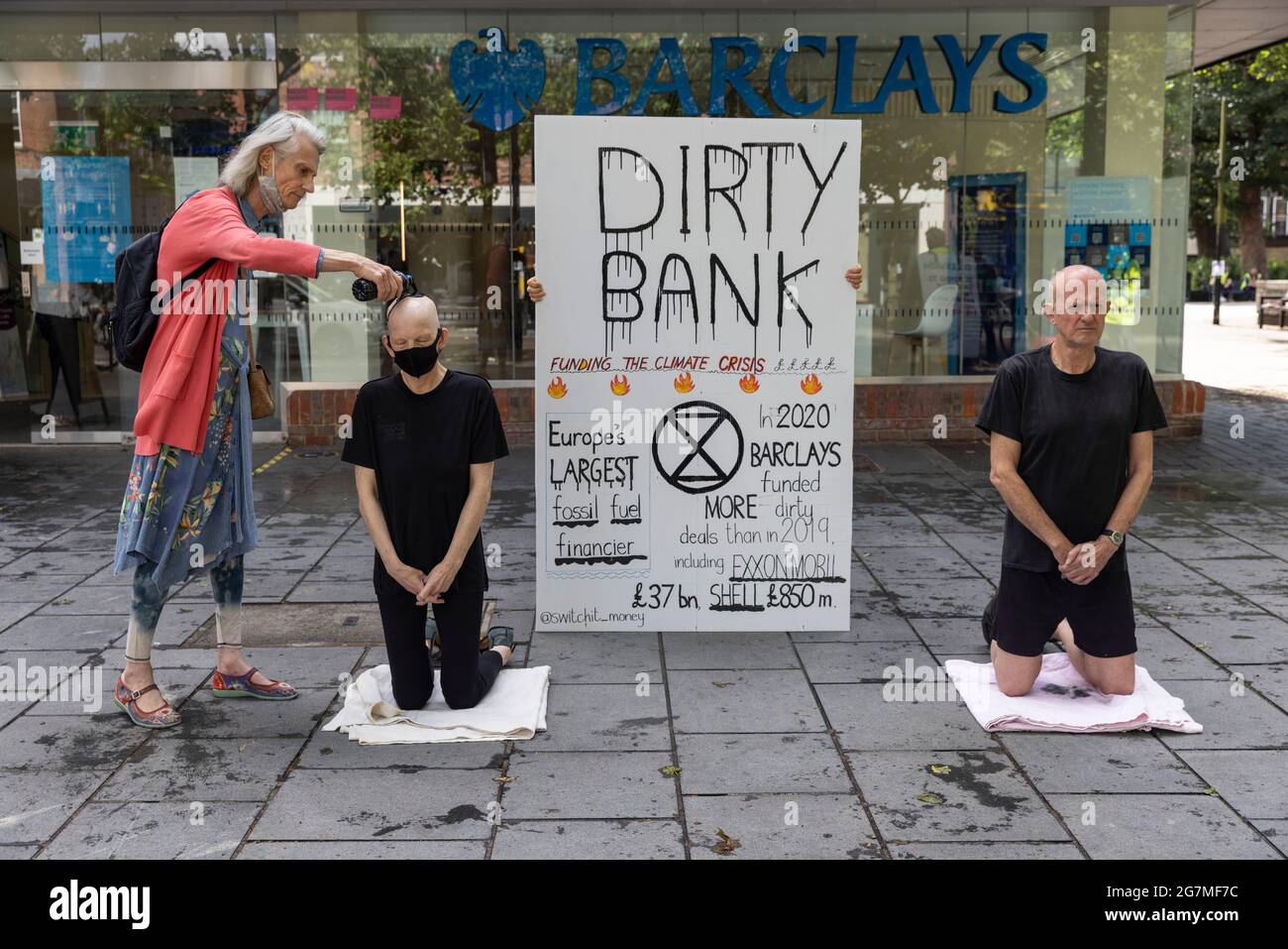 Climate protesters outside a Barclays Bank demonstrating against the banks financial investment in fossil fuels, St Albans, Hertfordshire, England, UK Stock Photo