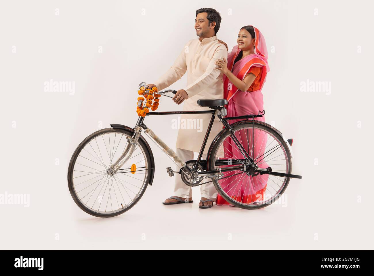 A RURAL COUPLE LOOKING AHEAD WHILE STANDING WITH NEW BICYCLE Stock Photo