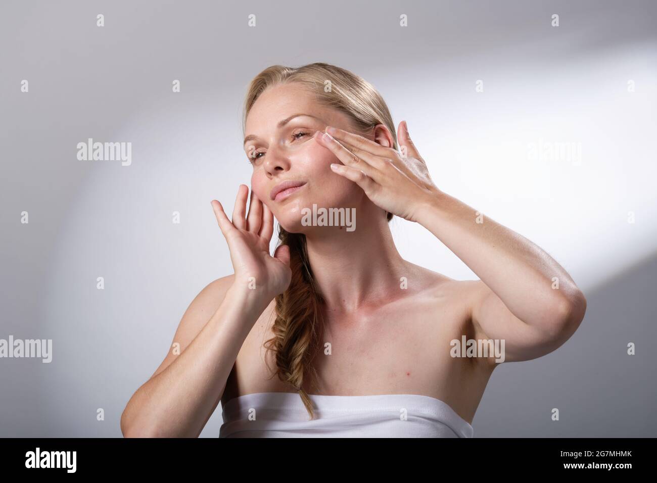 Beauty treatment regime by using hands and fingers to gently massage the face. Calm and relaxation. Me time. Stock Photo